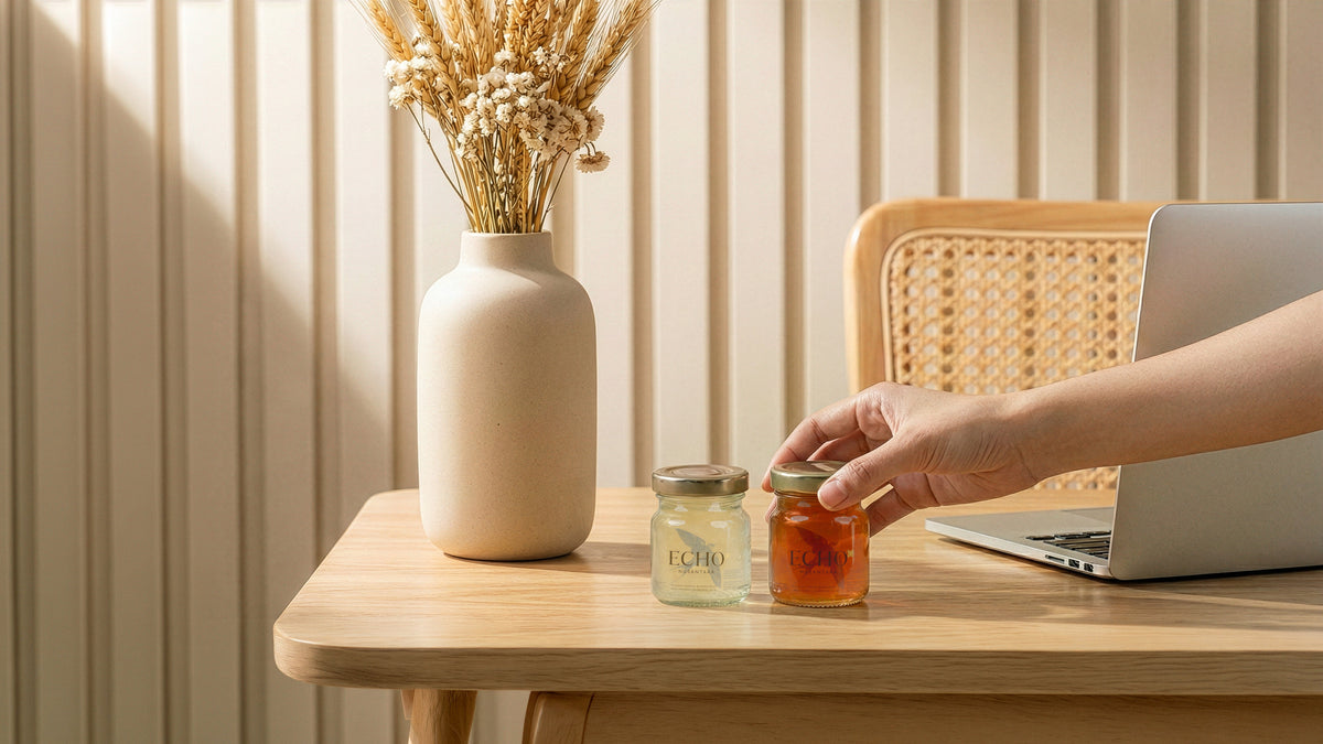 Hand reaching for Echo Nusantara 70ml bottled bird's nest on a wooden desk